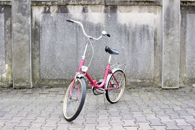 Bicycle on footpath by wall