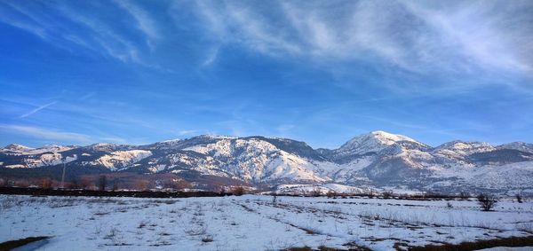 Scenic view of snowcapped mountains against blue sky