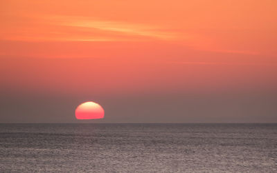 Scenic view of sea against orange sky