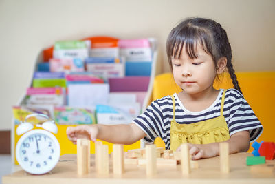 Cute girl playing with toy at home