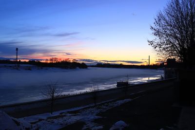 Scenic view of snow covered landscape against sky during sunset