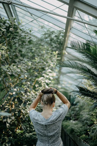 Rear view of woman standing by plants