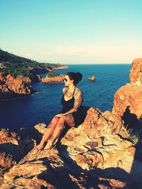 Woman in sea against sky