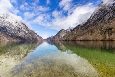 Scenic view of lake by mountains against sky