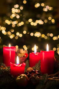 Close-up of burning candles amidst christmas decoration
