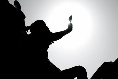 Low angle view of silhouette boy against clear sky