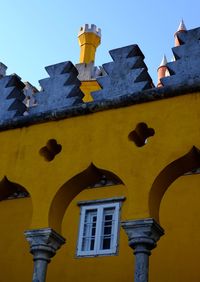 Low angle view of yellow building against clear sky