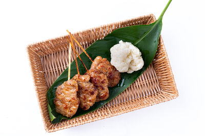 High angle view of meat and leaves on white background