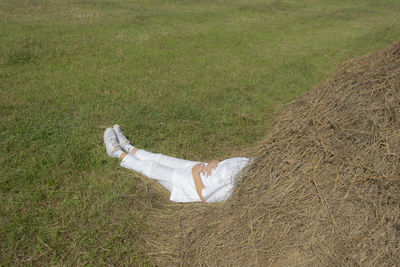 Low section of woman lying on grassy field