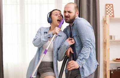 Young man and woman standing against wall