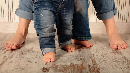 Low section of father and son standing on floor