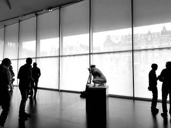 Silhouette people walking on glass window