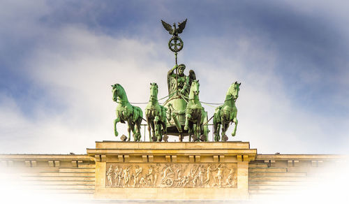 Low angle view of brandenburg gate against cloudy sky