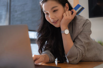 Businesswoman using laptop while sitting on table