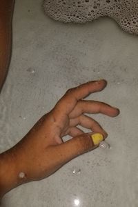 Close-up of woman hand on sand