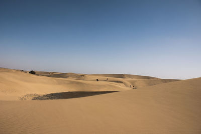 Scenic view of desert against clear blue sky