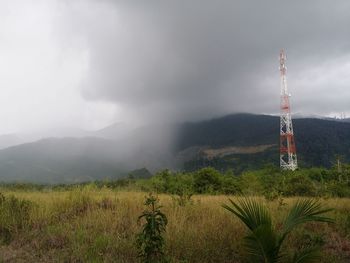 Communications tower on land against sky