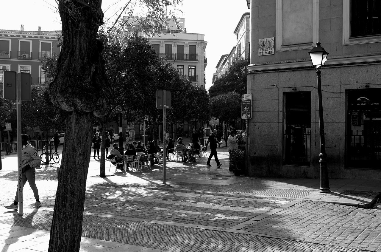 PEOPLE WALKING ON STREET AMIDST BUILDINGS