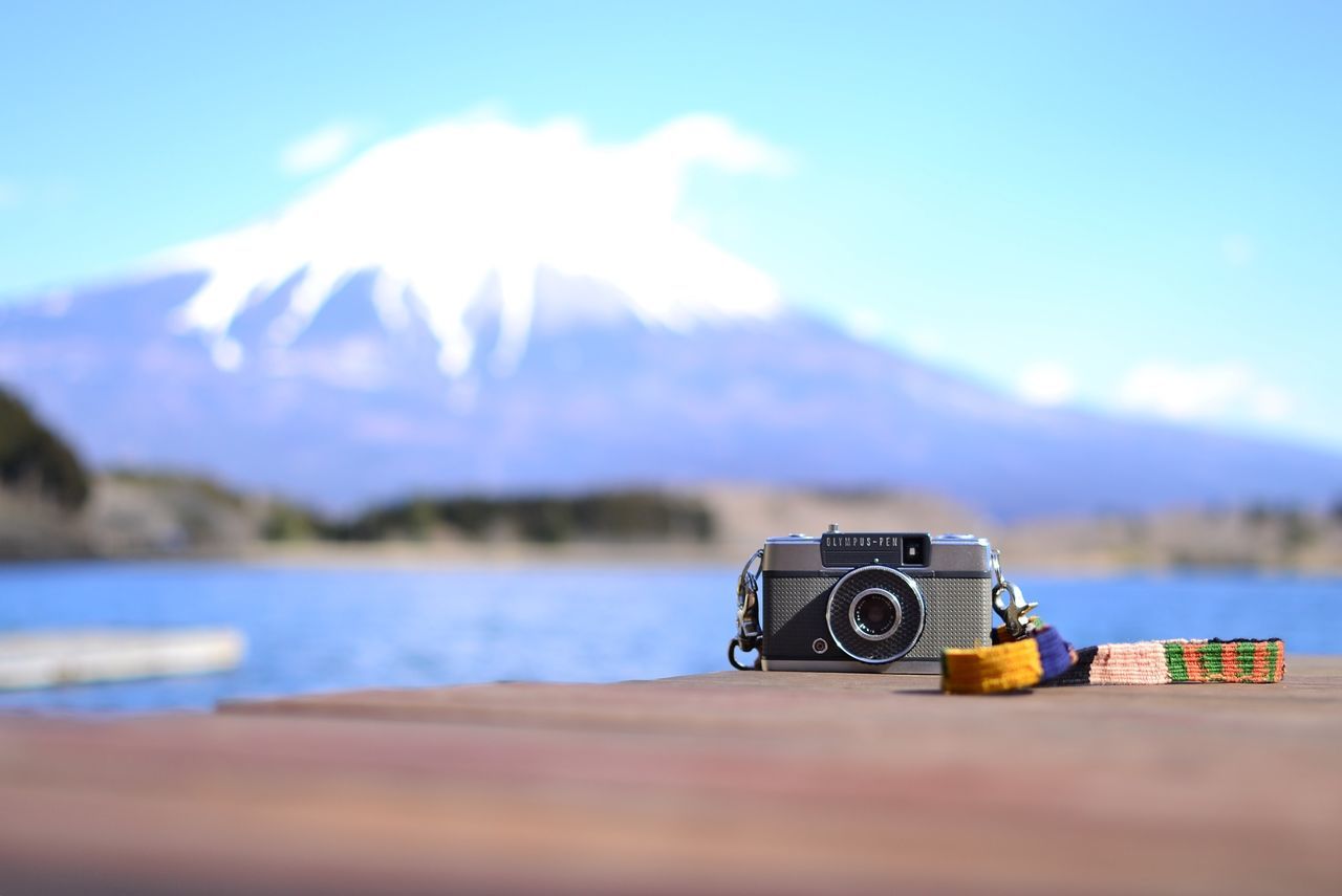 focus on foreground, sky, selective focus, close-up, tranquility, photography themes, tranquil scene, water, sea, mountain, one person, outdoors, nature, scenics, lake, beauty in nature, blue, cloud - sky, technology, cloud