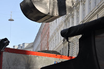 Low angle view of street light against buildings in city
