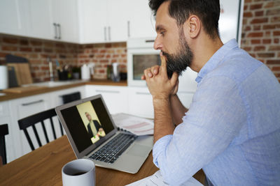 Businessman on video call through laptop at home office