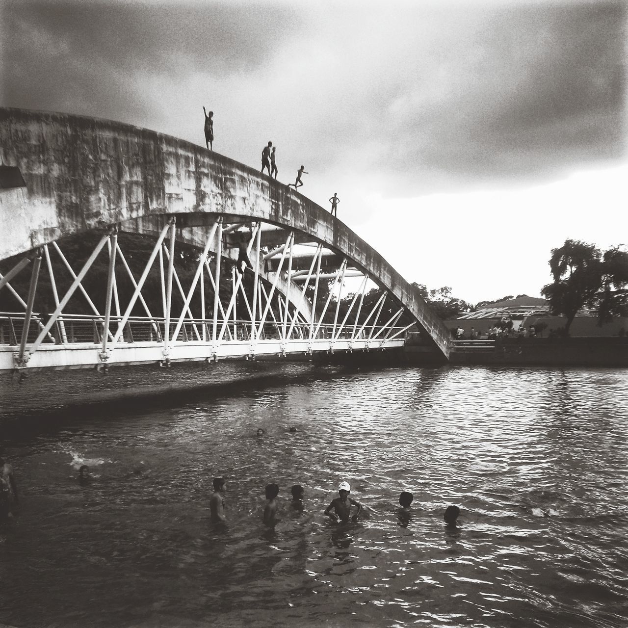 water, built structure, architecture, bridge - man made structure, connection, river, sky, waterfront, bridge, rippled, transportation, engineering, cloud - sky, reflection, outdoors, nature, arch bridge, bird, footbridge, day