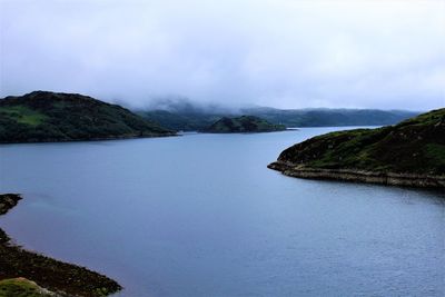 Scenic view of sea and mountains against sky