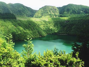 Scenic view of pond by landscape and mountains against clear sky