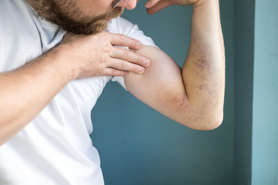 Midsection of man with arms crossed