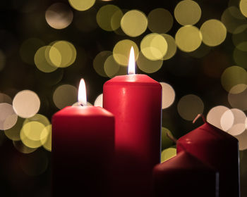 Close-up of illuminated candles against christmas lights