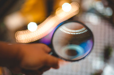 Close-up of person holding magnifying glass