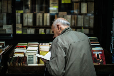 Rear view of man reading book