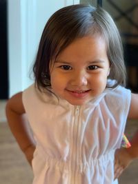 Portrait of cute smiling girl standing at home