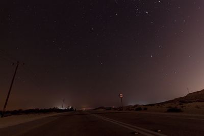 Road against clear sky at night