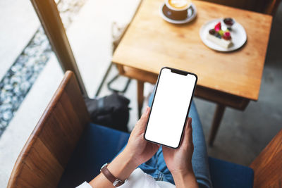 Midsection of woman using mobile phone on table