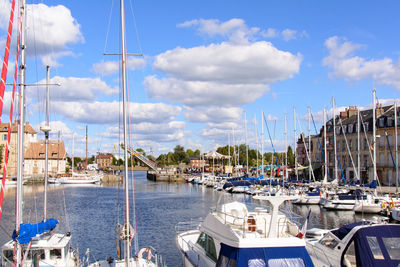 Sailboats moored at harbor