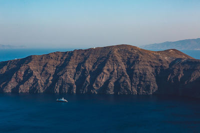 Scenic view of sea and mountains against clear sky