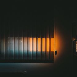 Low angle view of illuminated lamp hanging on wall at home