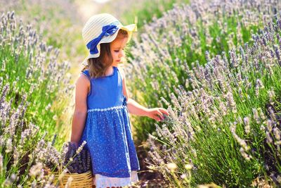 Woman standing on field by flowering plants
