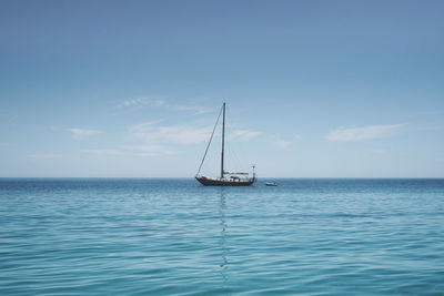 Sailboat sailing on sea against sky