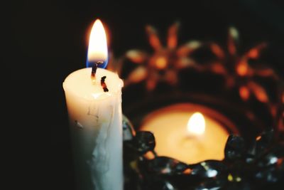 Close-up of lit candle in darkroom