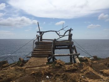 Lifeguard hut by sea against sky