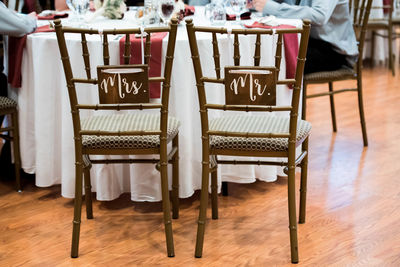 Text on empty chairs on hardwood floor during wedding ceremony