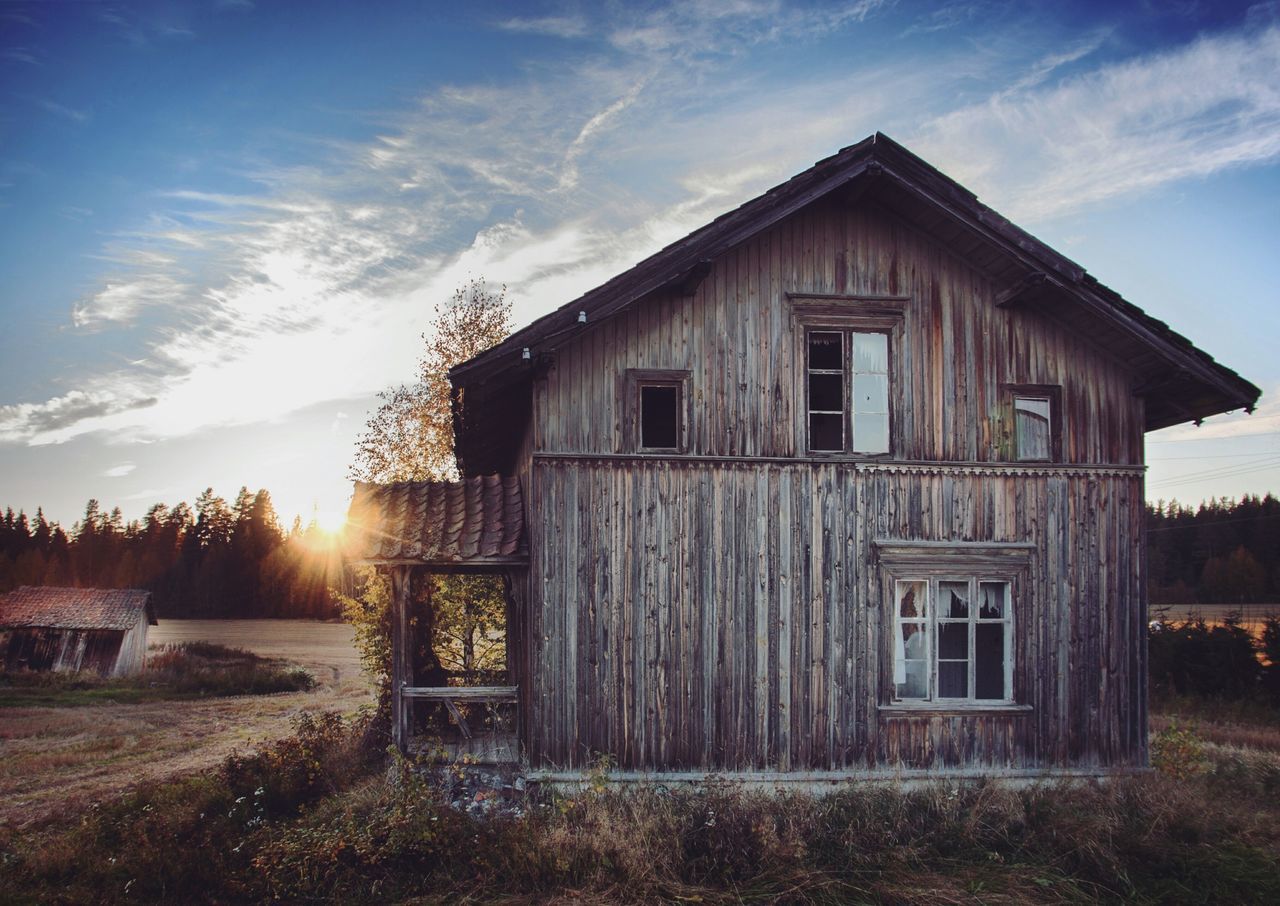 architecture, built structure, building exterior, sky, house, cloud - sky, field, grass, cloud, sunlight, abandoned, residential structure, outdoors, nature, no people, barn, window, day, rural scene, plant