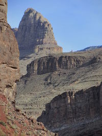 Low angle view of rocky mountain against clear sky