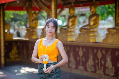 Portrait of young woman standing in city