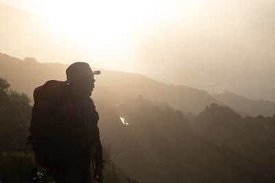 Man looking at mountains against sky