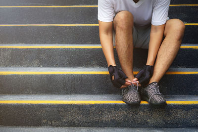 Low section of man sitting on road