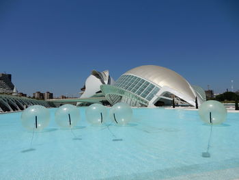 View of swimming pool against clear blue sky - city of arts and science in valencia, spain. 