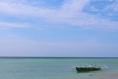 Sailboat in sea against sky